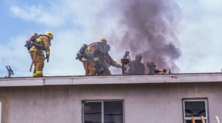 firefighters on roof cutting hole (vertical ventilation)